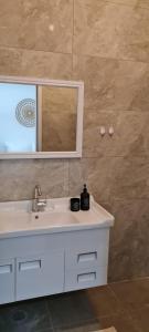 a bathroom with a white sink and a mirror at Desert Shine in Qiryat Gat