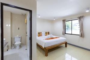 a bedroom with a bed and a bathroom with a toilet at PMS Boutique Patong in Patong Beach