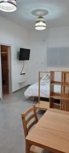 a living room with a table and a bed at Desert Shine in Qiryat Gat
