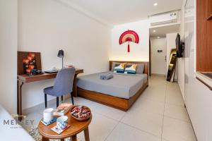 a bedroom with a bed and a desk and a table at Mersey Ben Thanh Saigon Apart'Hotel in Ho Chi Minh City