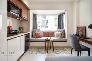 a kitchen with a window with a desk and a table at Mersey Ben Thanh Saigon Apart'Hotel in Ho Chi Minh City