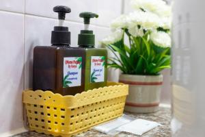 a yellow basket with two bottles of soap and flowers at PMS Boutique Patong in Patong Beach