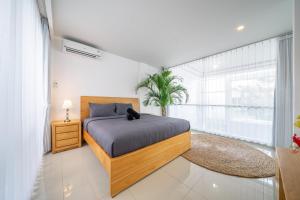 ein Schlafzimmer mit einem Bett mit einer schwarzen Katze auf dem Bett in der Unterkunft The View Villa 10 - 2br Cozy Loft in Uluwatu in Uluwatu + 15 Fotos