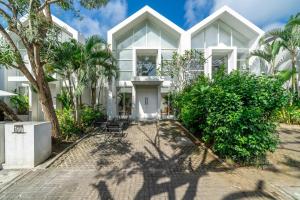 eine Außenansicht eines weißen Gebäudes mit Palmen in der Unterkunft The View Villa 10 - 2br Cozy Loft in Uluwatu in Uluwatu
