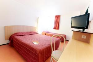 Habitación de hotel con cama y TV de pantalla plana. en Première Classe Rouen Nord - Bois Guillaume, en Bois-Guillaume
