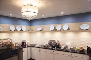 a large kitchen with white plates on the wall at Country Inn & Suites by Radisson, Frackville (Pottsville), PA in Mount Pleasant