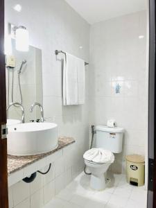 a white bathroom with a sink and a toilet at PMS Boutique Patong in Patong Beach