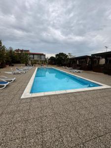 a large swimming pool with chairs and a building at Mobilheim Camping 6 Personen Pool am Meer in Turanj +11 photos