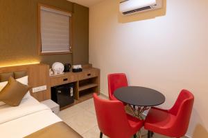 a room with a bed and a table and red chairs at MEDLEY REGENCY in Palakkad