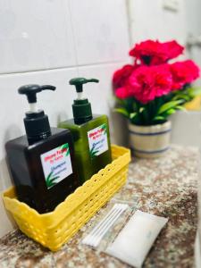 a yellow basket with two bottles of soap and flowers at PMS Boutique Patong in Patong Beach