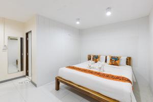 a white bedroom with a large bed and a mirror at PMS Boutique Patong in Patong Beach