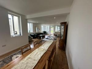 a large living room with a large wooden table at North London A spacious 7 bedroom house accommodating up to 18 people complete with own gym and table tennis in London