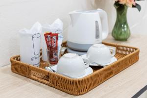 a tray with a tea set and cups on a table at PMS Boutique Patong in Patong Beach