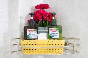 a basket with two bottles of soap and flowers at PMS Boutique Patong in Patong Beach