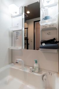 een badkamer met een wastafel met een spiegel en een wastafel bij Estrella in Sapporo +30 foto's