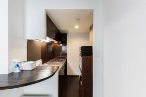 een keuken met een spoelbak en een aanrechtblad bij Estrella in Sapporo