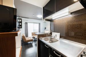 een keuken met een spoelbak en een aanrechtblad bij Estrella in Sapporo