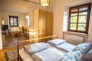 a bedroom with two beds and a living room at Ferienwohnung Altes Schulhaus Greising in Deggendorf