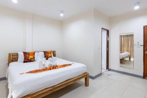 a bedroom with a large bed with white sheets at PMS Boutique Patong in Patong Beach