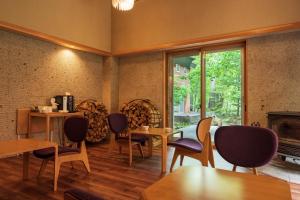 a room with chairs and tables and a window at 奥日光湯元温泉ゆの森 in Nikko