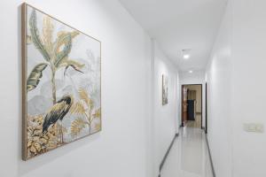 a hallway with a painting of birds on the wall at PMS Boutique Patong in Patong Beach