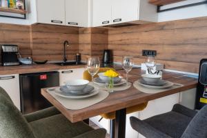 a kitchen with a wooden table with two glasses of wine at Студио Даневски-Balkan Tower in Gabrovo