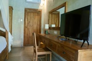 a television on a wooden dresser in a bedroom at Melati bali villa in Canggu