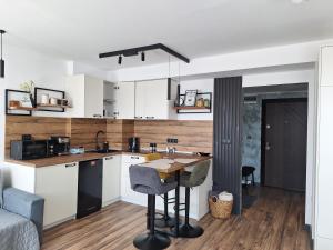 a kitchen with white cabinets and a wooden wall at Студио Даневски-Balkan Tower in Gabrovo