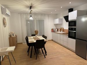 a kitchen and dining room with a table and chairs at Le Cocon du Paradis à 4 min du Zoo de Beauval in Saint-Aignan