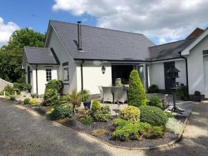 a white house with a garden in front of it at Spacious, Modern Bungalow in Newton Regis
