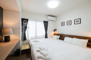 a bedroom with a large white bed with white pillows at FC Farnest Niseko in Kutchan