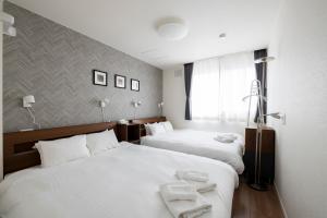 a hotel room with two beds and a window at FC Farnest Niseko in Kutchan