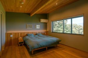 小諸市にある女性のための森サウナ 一棟貸し宿 SORA 宙 Forest sauna villa SORAのベッドルーム1室(ベッド1台、大きな窓付)