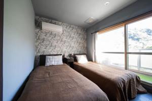 a bedroom with a bed and a large window at Few Days Condominium 602 in Jozankei
