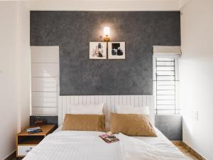 a bedroom with a large white bed with two pictures on the wall at Avalon Homes in Perintalmanna