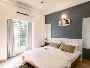 a bedroom with a large white bed and a window at Avalon Homes in Perintalmanna
