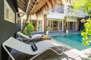 塞米亚克NEW Villa Indah Seminyak 3BR Private Pool的一个带游泳池和两张躺椅的度假胜地