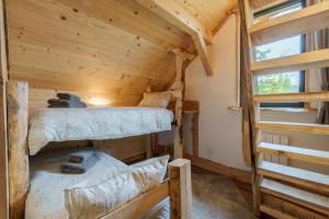 two bunk beds in a log cabin with a window at Chalet Chataigne - Magnifique vue montagne in Cornimont