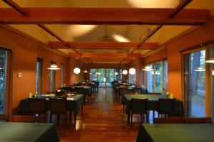 a dining room with tables and chairs and windows at 奥日光湯元温泉ゆの森 in Nikko