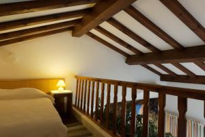 a bedroom with a bed and a staircase with wooden beams at COCON AUX SENTEURS de CORSE et VUE EXCEPTIONNELLE in Linguizzetta +32 photos