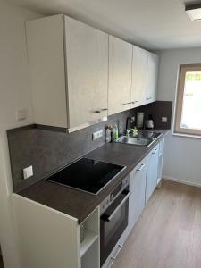 a kitchen with white cabinets and a sink at ammersee apARTment Dießen in Dießen am Ammersee