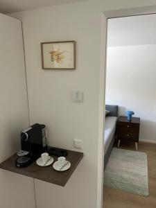 a room with a table with two cups and a television at ammersee apARTment Dießen in Dießen am Ammersee