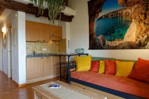 a living room with a couch and a kitchen at COCON AUX SENTEURS de CORSE et VUE EXCEPTIONNELLE in Linguizzetta