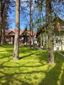a group of trees in front of a house at Amber Hill Apartment in Juodkrantė