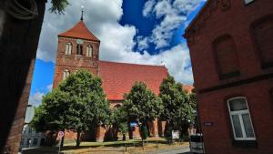a large red brick building with a clock tower at Ferienwohnungen Seewald in Teterow +5 photos
