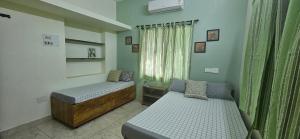 哥印拜陀SHIs Aathira 2bhk Heart of Coimbatore的有两张床和一扇窗户的小房间