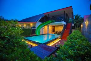 a house with a swimming pool in front of a house at Private Room in Ban Klang
