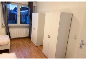 two white cabinets in a room with a window at Zentrale Wohnung mit Küche & 4 Betten in Oelde Stay Nest in Oelde