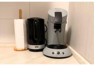 a white and black coffee maker sitting on a counter at Zentrale Wohnung mit Küche & 4 Betten in Oelde Stay Nest in Oelde +2 photos