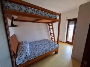 アルデーアにあるSea & Beach front house Marina di Ardeaのベッドルーム1室(二段ベッド2台、はしご付)
